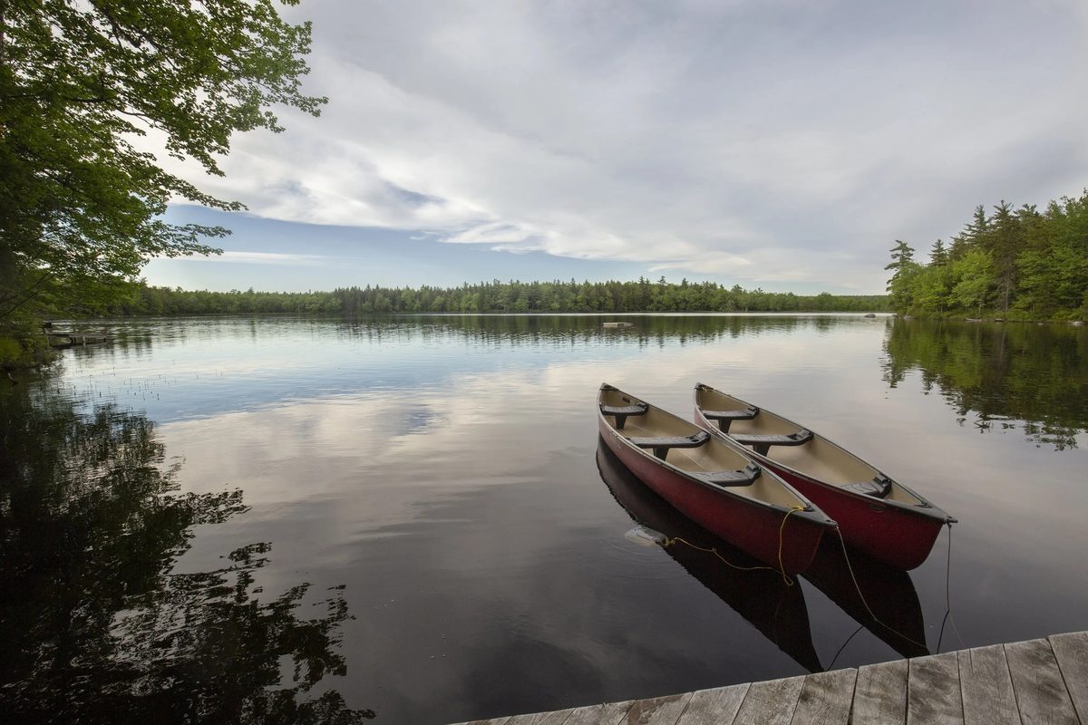 Red canoes at a dock on a calm lake